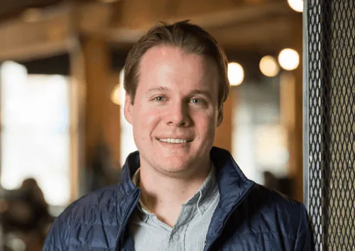 A man wearing a blue jacket and a white shirt.