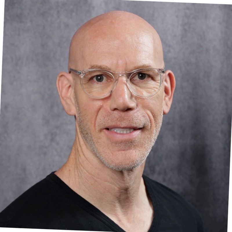 A bald man wearing glasses and a black shirt.