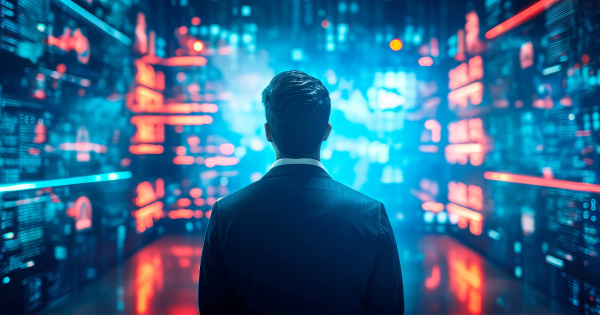 A man wearing a suit and tie stands in front of a screen of red and blue lights.
