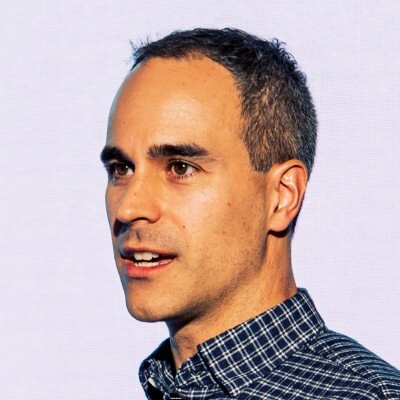 A man with a blue plaid shirt and short brown hair.